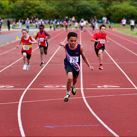 a child in SSAthletic's garb frontrunning in a track race