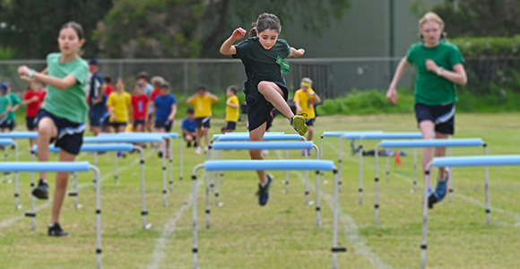 three children in a hurdle race over hurdles