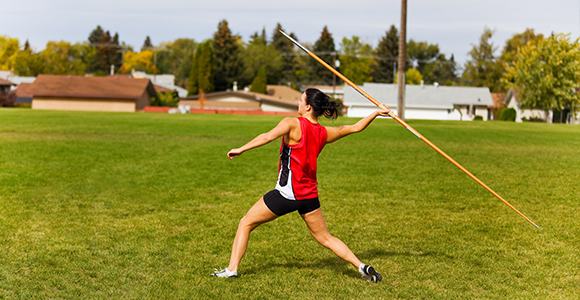 a lady preparing to throw a javelin across a field