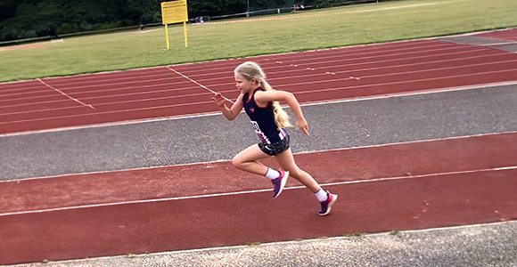 a girl performing a run up to a long jump pit